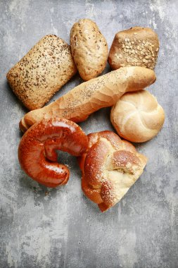 Gri taş arka plan üzerinde çeşitli çörekler.