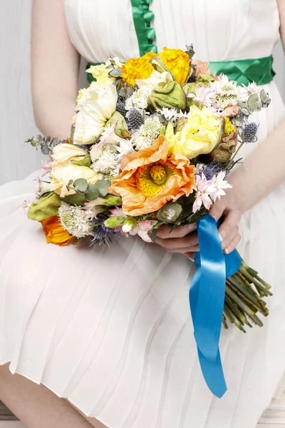 Mulher de vestido branco segurando um buquê de casamento de papoilas e ca — Fotografia de Stock