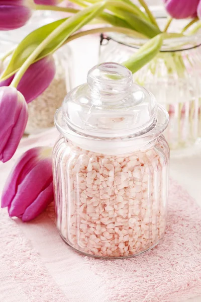 Skleněná nádobka z růžové mořské soli na bílém dřevěném stole, Tulipán — Stock fotografie