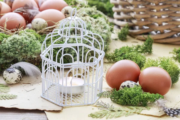 Etrafında mum, yosun ve Paskalya yumurtaları ile Vintage kuş kafesi.