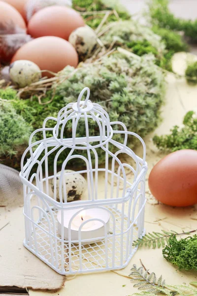Etrafında mum, yosun ve Paskalya yumurtaları ile Vintage kuş kafesi.