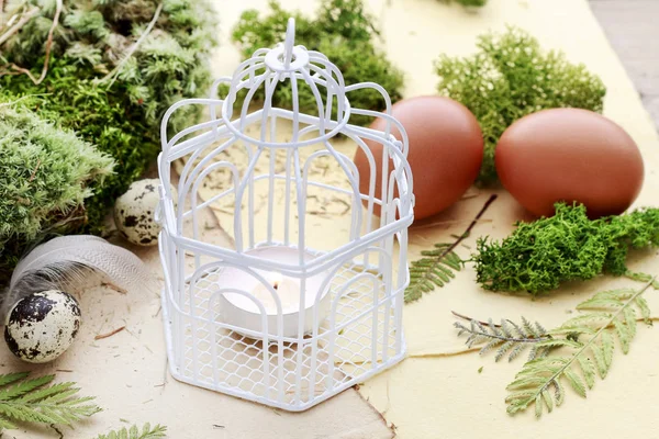 Etrafında mum, yosun ve Paskalya yumurtaları ile Vintage kuş kafesi.