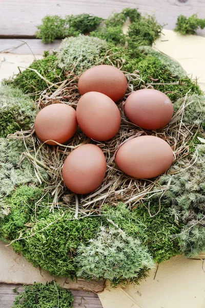 Decoración de mesa de Pascua con corona de musgo, heno y huevos . —  Fotos de Stock
