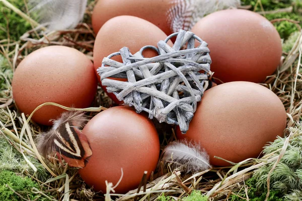 Decoración de mesa de Pascua con corona de musgo, heno y huevos . —  Fotos de Stock