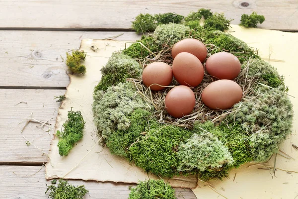 Yosun çelenk, saman ve yumurta ile Paskalya masası dekorasyonu. 