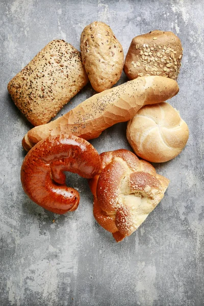 Gri taş arka plan üzerinde çeşitli çörekler.