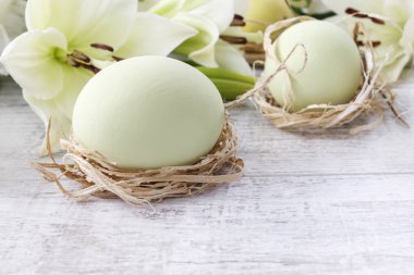 Ahşap arka planda Beyaz lilyum ve Paskalya yumurtası