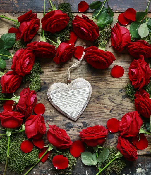 Wooden heart among red roses, copy space. Valentine's Day backgr — Stock Photo, Image