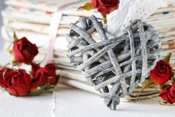Wicker heart, stack of letters and dried roses. — Stock Photo, Image