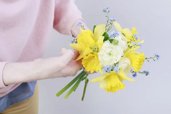 Cómo hacer un ramo de primavera con narcisos, ranúnculos y frenos. — Foto de Stock