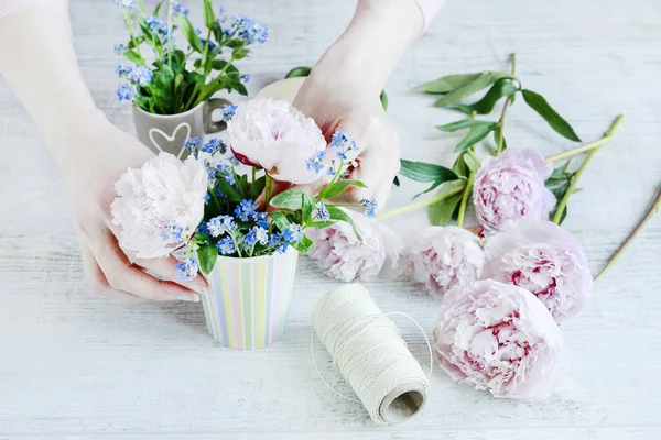 Mujer arreglando ramos con peonías y flores de olvidarme-no —  Fotos de Stock