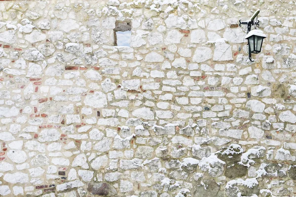 Πέτρινος τοίχος με σιδερένιο φανάρι και ένα μικρό παράθυρο. — Φωτογραφία Αρχείου
