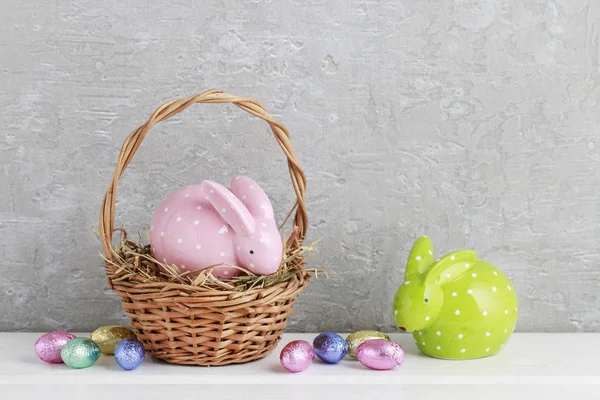 Two rabbits and traditional Easter basket with eggs. — Stock Photo, Image