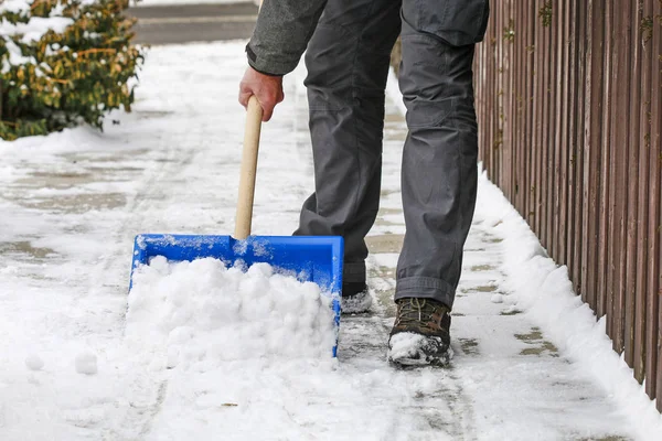 Muž, odstranění sněhu z chodníku po sněhové bouři. — Stock fotografie