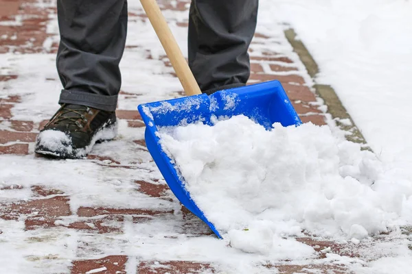 在暴风雪后从人行道上除雪的人. — 图库照片