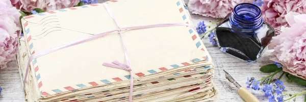 Stack di lettere d'amore vintage e peonie rosa sullo sfondo — Foto Stock