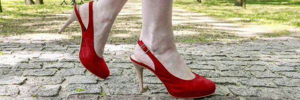 Jovem mulher usando sandálias, andando sobre o stre de paralelepípedos — Fotografia de Stock