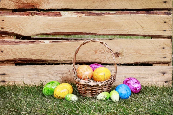 Tradycyjny kosz wielkanocny z kolorowymi jajkami. — Zdjęcie stockowe