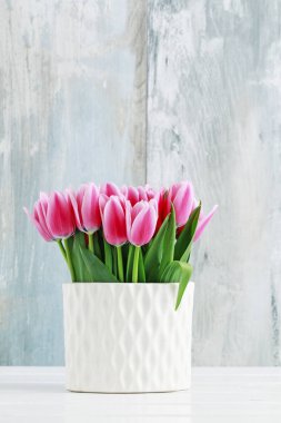 Beyaz seramik vazoda pembe laleler