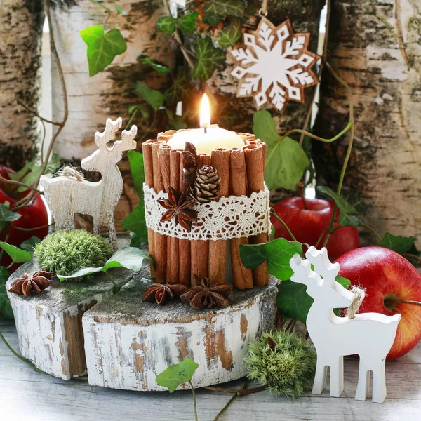 Candle decorated with cinnamon sticks, moss, ivy leaves and wood — Stock Photo, Image