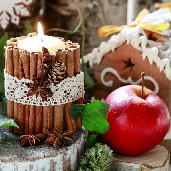 Bougie décorée de bâtonnets de cannelle, mousse, feuilles de lierre et bois — Photo