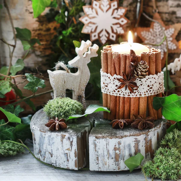 Candle decorated with cinnamon sticks, moss, ivy leaves and wood — Stock Photo, Image