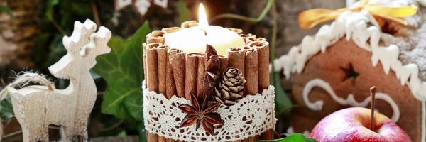 Candle decorated with cinnamon sticks, moss, ivy leaves and wood — Stock Photo, Image