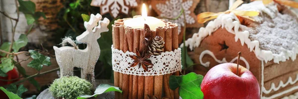 Candle decorated with cinnamon sticks, moss, ivy leaves and wood — Stock Photo, Image