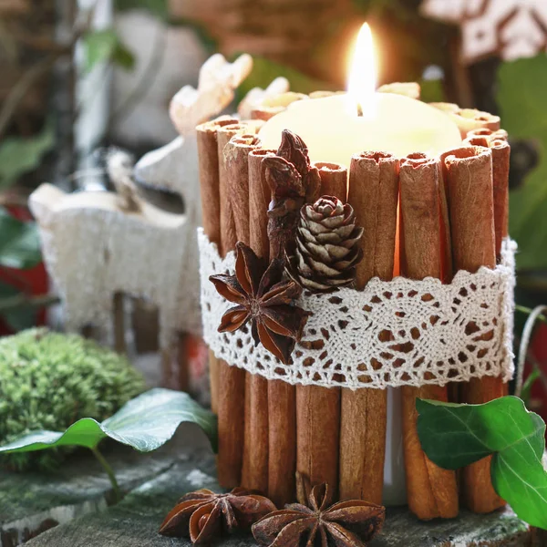 Ljus dekorerad med kanel pinnar, mossa, murgröna blad och trä — Stockfoto