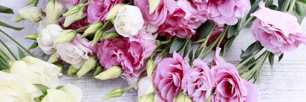 Flores de eustoma rosa e amarelo (lisianthus) na mesa . — Fotografia de Stock