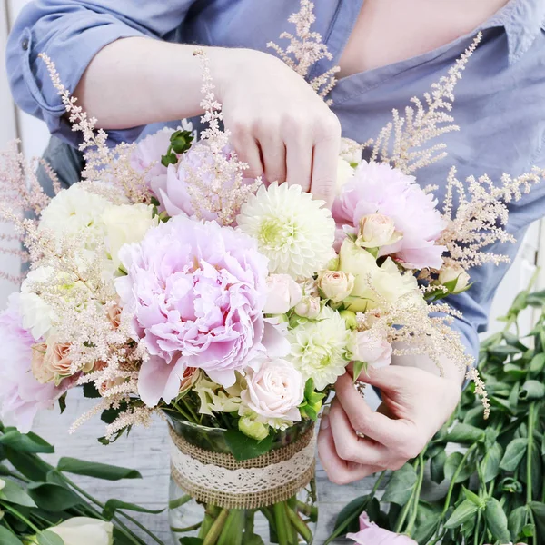 Donna che organizza bouquet con peonie rosa, rose e dahl giallo — Foto Stock