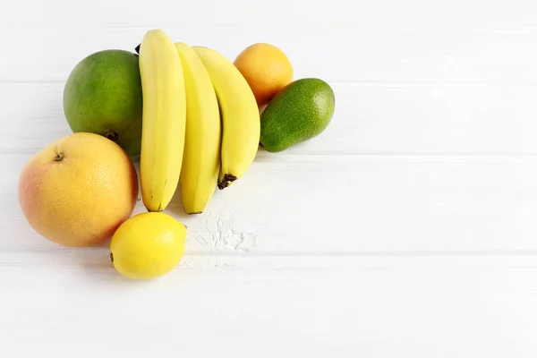 Various fruits on white wooden background — Stock Photo, Image