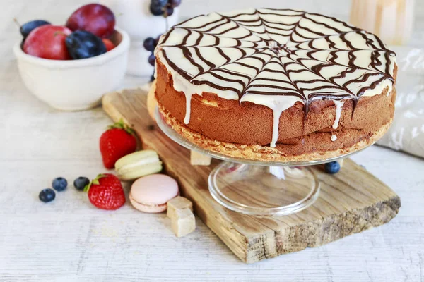 Halloween czekolada pajęczyna ciasto i różne owoce wokół. — Zdjęcie stockowe