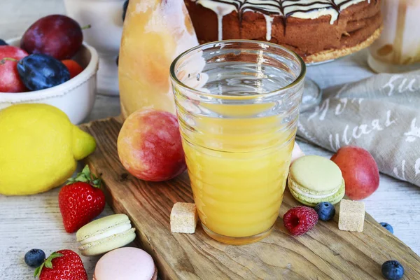 Copo de suco de laranja entre vários frutos . — Fotografia de Stock