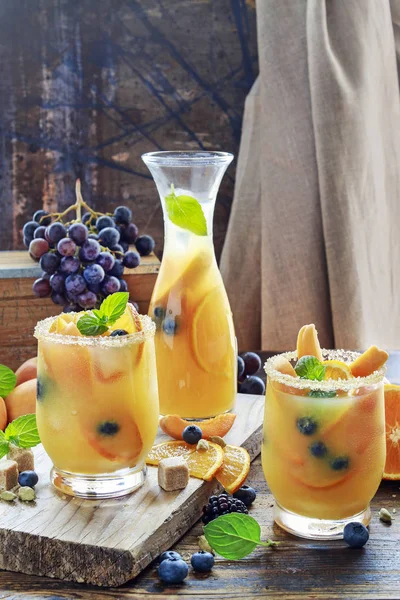 Bebida de verão com pêssegos, laranjas e mirtilos . — Fotografia de Stock
