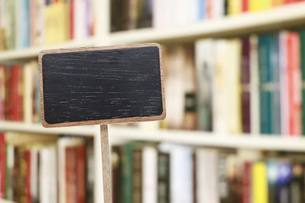 Etiqueta de quadro-negro em branco e biblioteca embaçada em segundo plano . — Fotografia de Stock