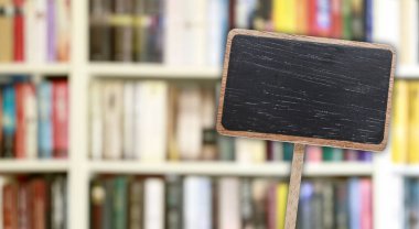 Blank blackboard label and blurred library in the background.  clipart