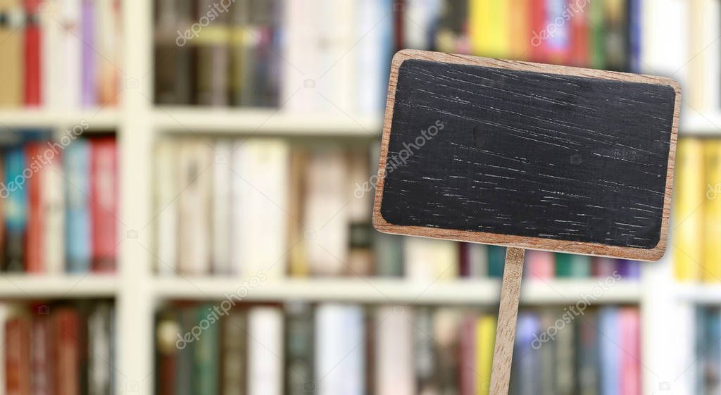 Blank blackboard label and blurred library in the background. 