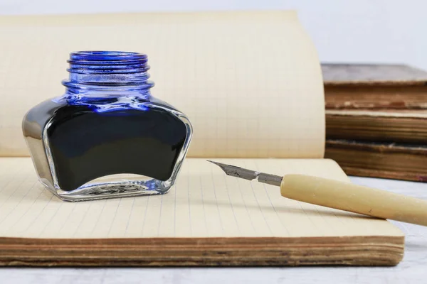 Inkwell, pen en een oude notebook. — Stockfoto