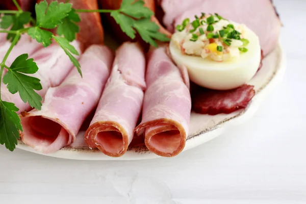 Plate with sliced ham and stuffed eggs. — Stock Photo, Image