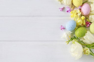 Beyaz ahşap masa üzerinde lale ler ve freesias. Flo arasında Paskalya yumurtaları