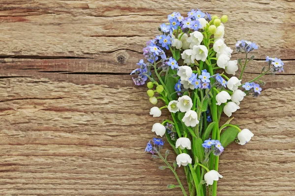 Blumenstrauß von Vergissmeinnicht und Maiglöckchen auf Holz — Stockfoto