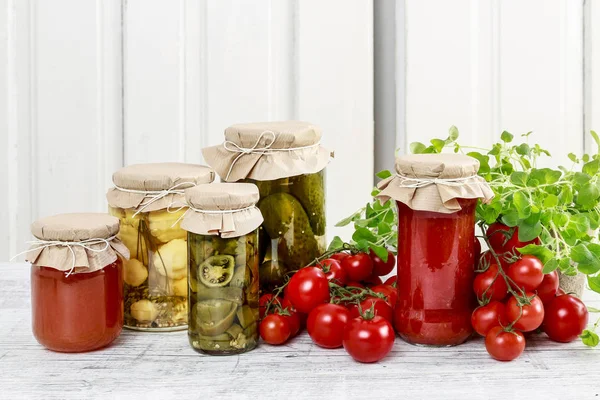 Jars of preserves and fresh vegetables. — Stock Photo, Image