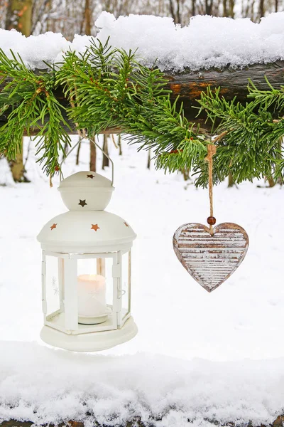 Ghirlanda di abete, lanterna di ferro e cuori di legno appesi in inverno ga — Foto Stock