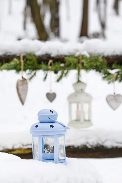 Ghirlanda di abete, lanterna di ferro e cuori di legno appesi in inverno ga — Foto Stock