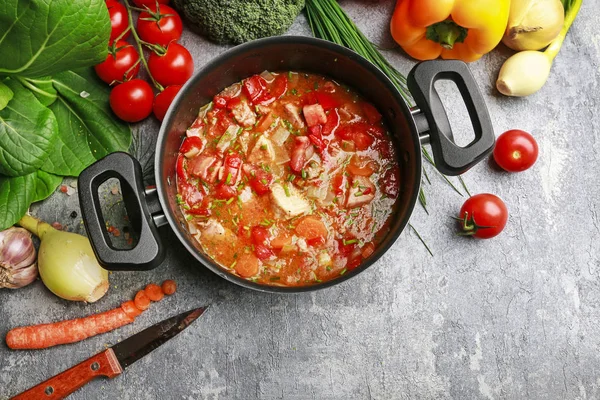 Gulášová polévka a barevná zelenina na šedé kamenné pozadí. — Stock fotografie