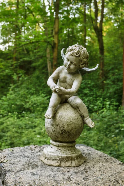 Baby Angel lub amorek figura wykonana z kamienia w ogrodzie. — Zdjęcie stockowe