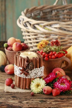 Sonbahar meyveleri ve fl arasında tarçın çubukları ile süslenmiş mum