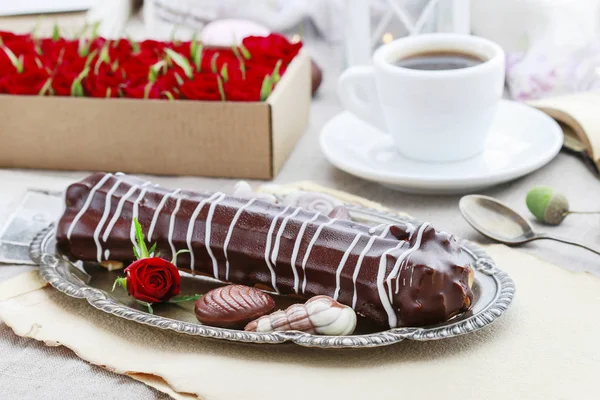 Eclair with chocolate and cup of coffee. — Stock Photo, Image