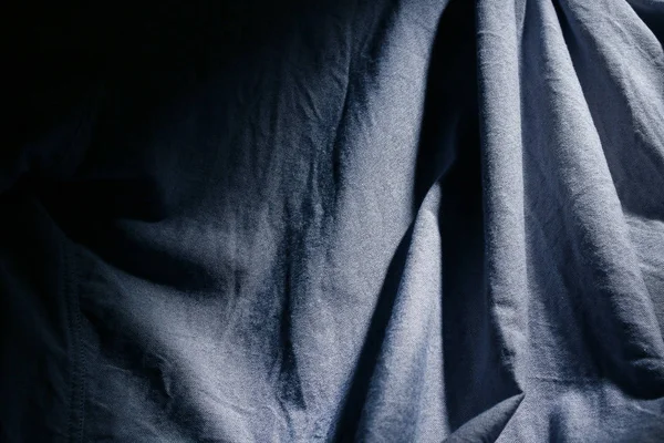 Dramatic lighting on denim fabric